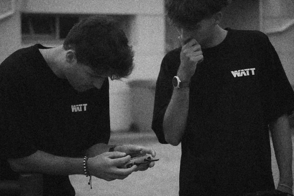 Deux membres de l'équipe WATT Production en tee-shirt WATT, en noir et blanc